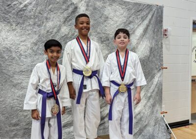 3 karate kids standing with medals